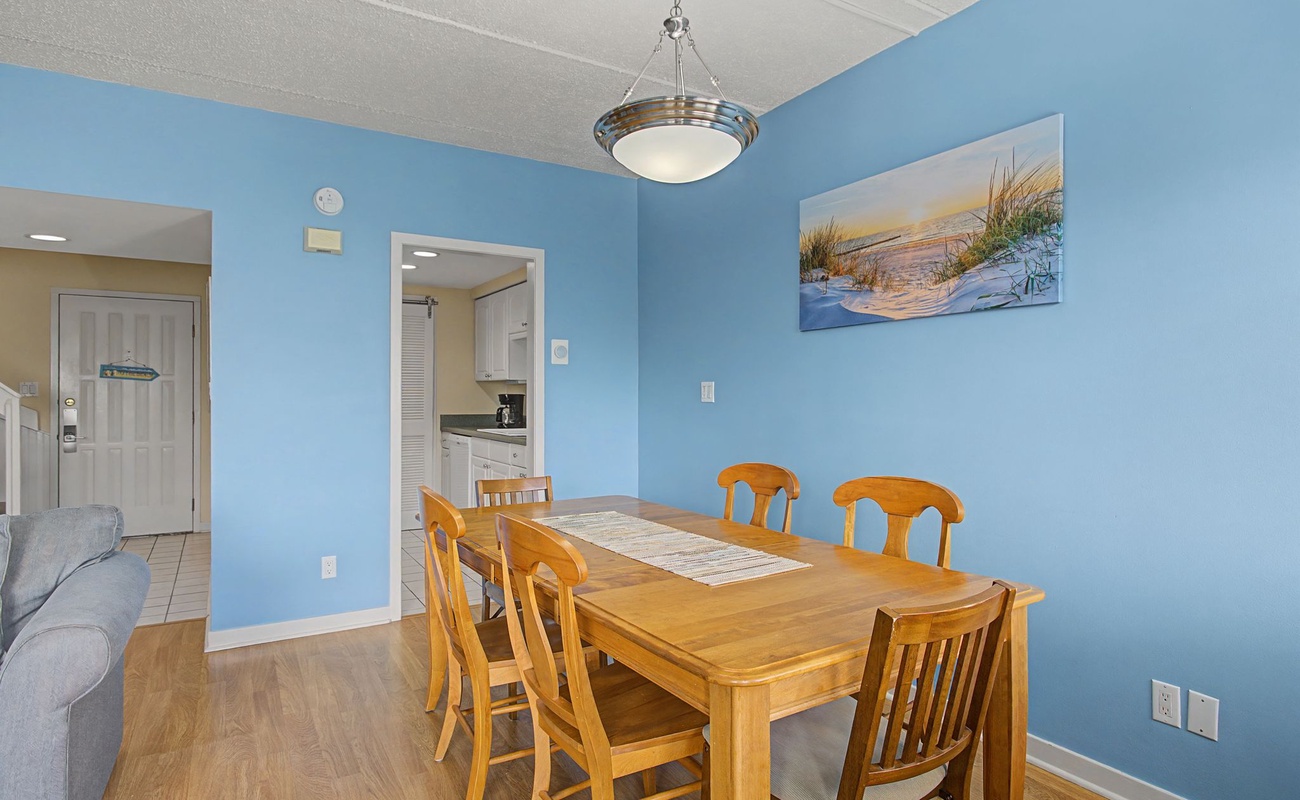 Gather around this welcoming dining table for memorable meals with loved ones in the bright, coastal-themed space.