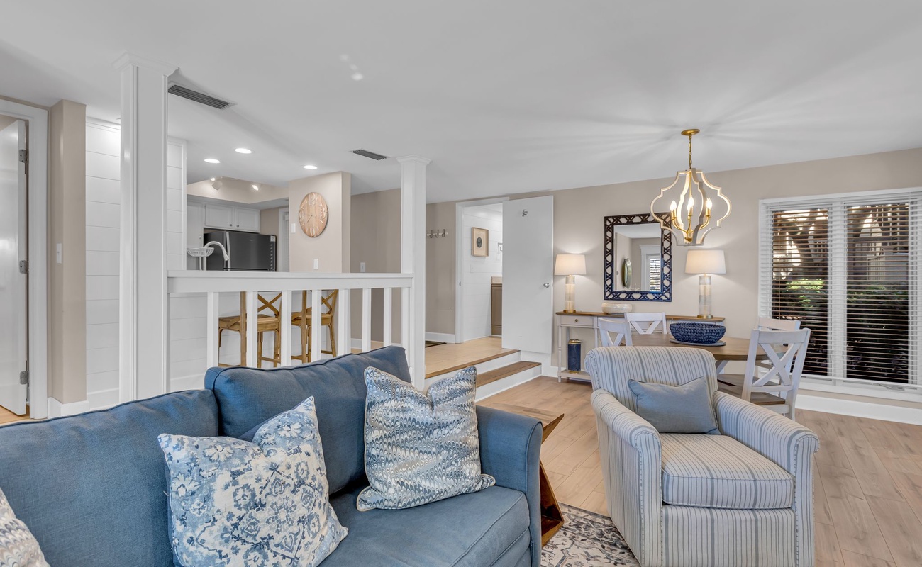 Sink into plush seating where coastal blues meet elegant neutrals, creating your perfect retreat for relaxation and connection.