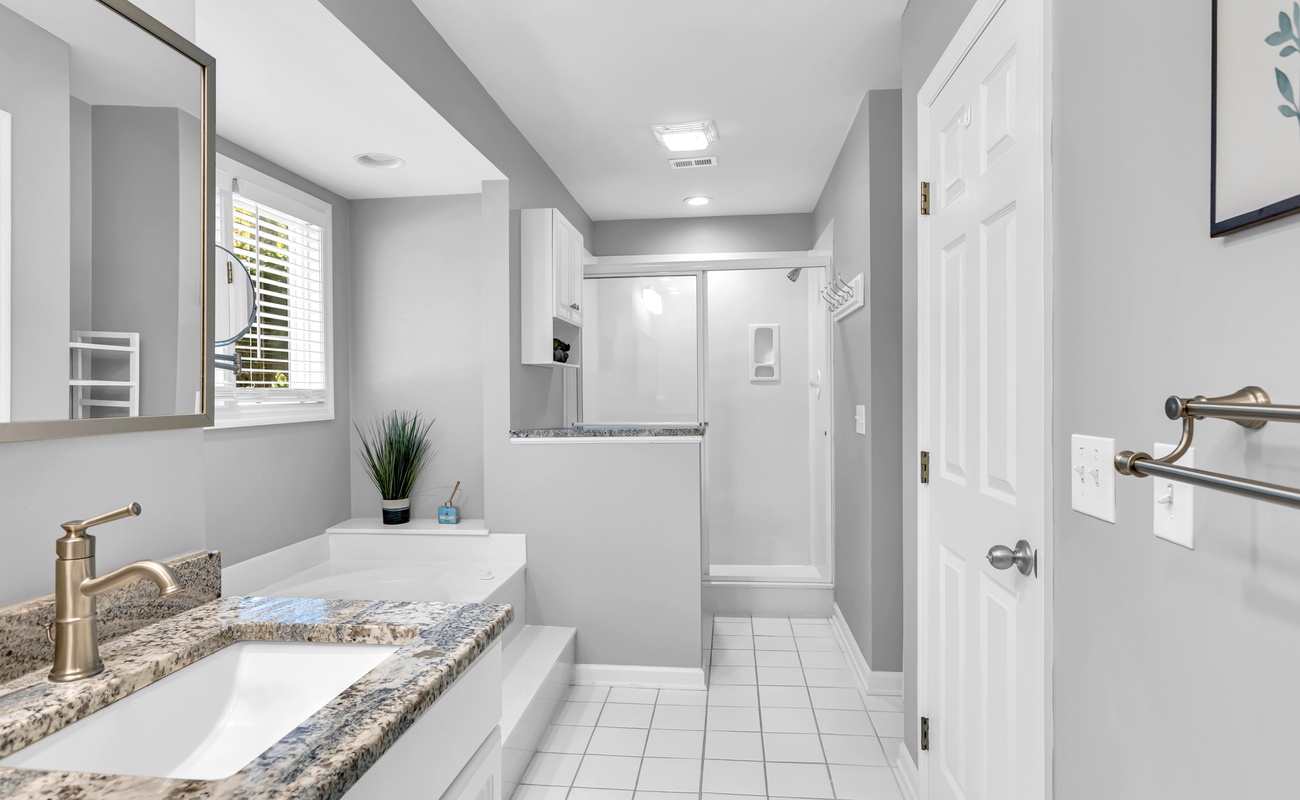 Step into your spacious bathroom featuring granite countertops, modern fixtures, and a refreshing glass-enclosed shower for your comfort.