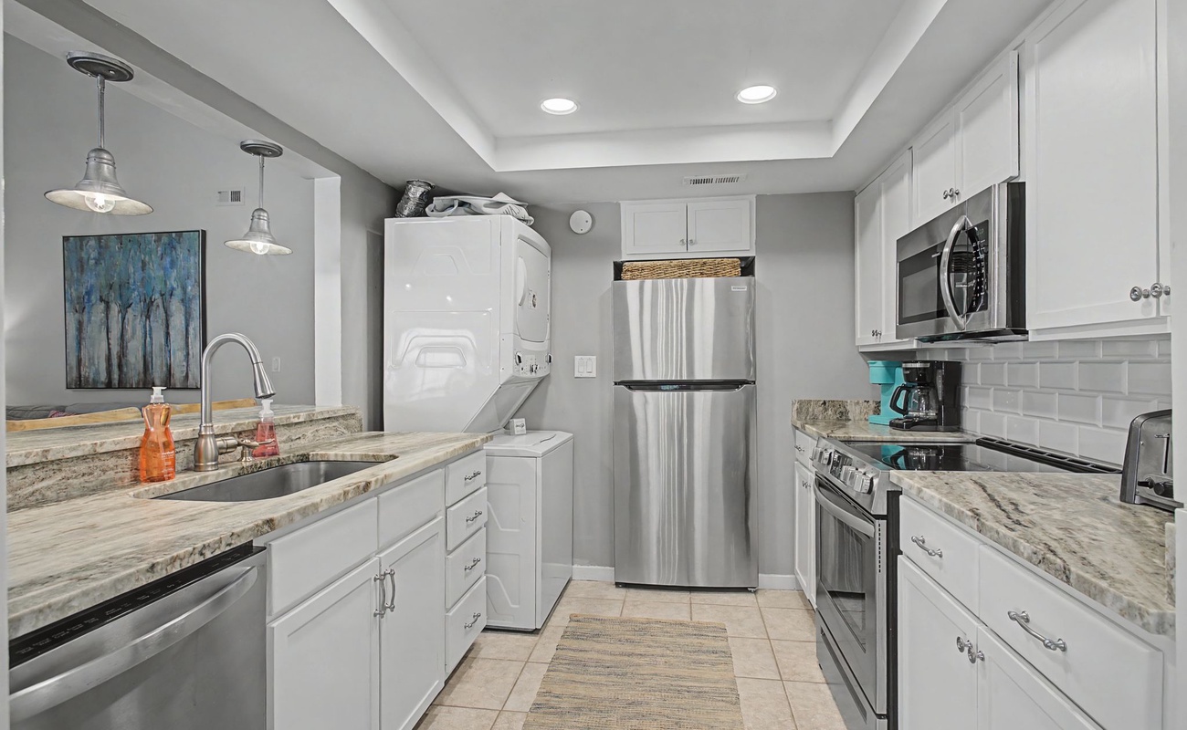 You'll love preparing meals in this stunning modern kitchen with granite countertops, stainless steel appliances, and elegant pendant lighting.