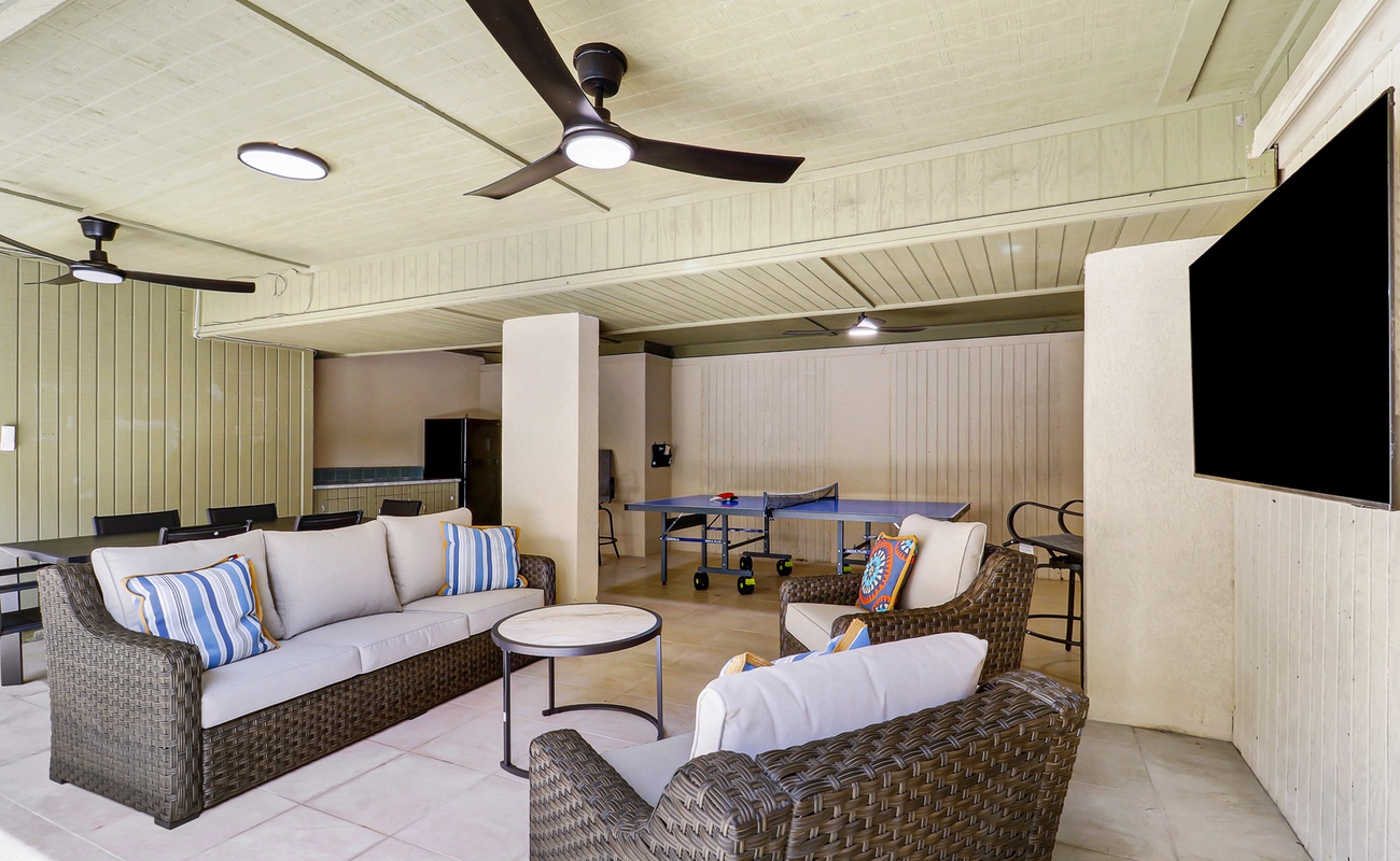 Relax in this elegant covered lounge where comfortable wicker furniture and ceiling fans create your perfect retreat for entertaining guests.