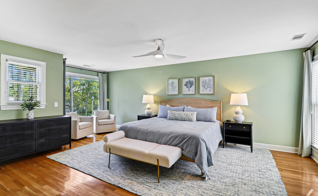 Serene and spacious bedroom retreat featuring a king bed, soft coastal tones, and a cozy seating area - perfect for unwinding after a day on the island.