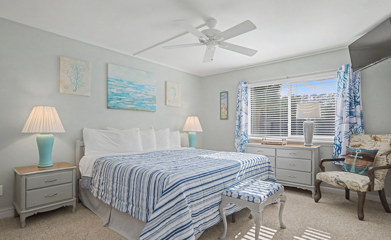 Drift off in your coastal-inspired bedroom, where soothing blues and crisp whites create a serene retreat with ocean artwork adorning the walls.