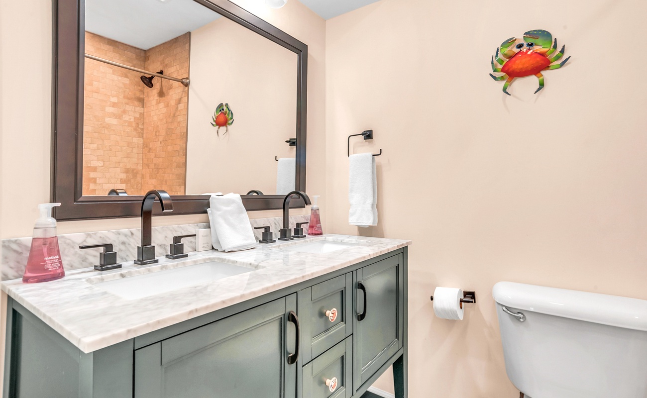 Refresh in your coastal-themed bathroom with dual sinks, marble counters, and charming crab décor that adds personality to your morning routine.