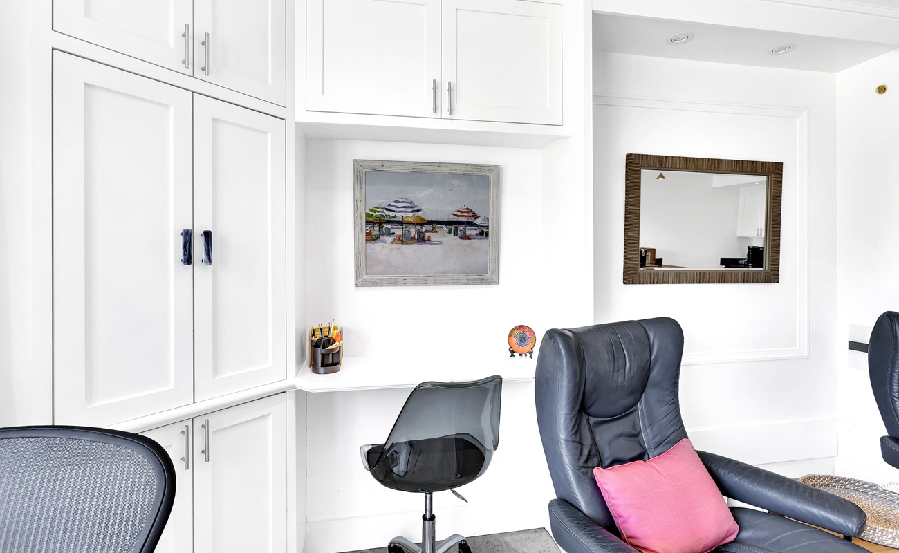 Settle into your stylish office space with custom white storage and comfy leather seating for productive work days.