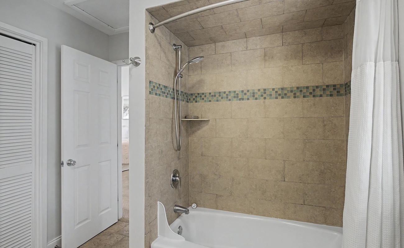 Your private bathroom features elegant stone-look tile and modern fixtures for a spa-like shower and bath experience.