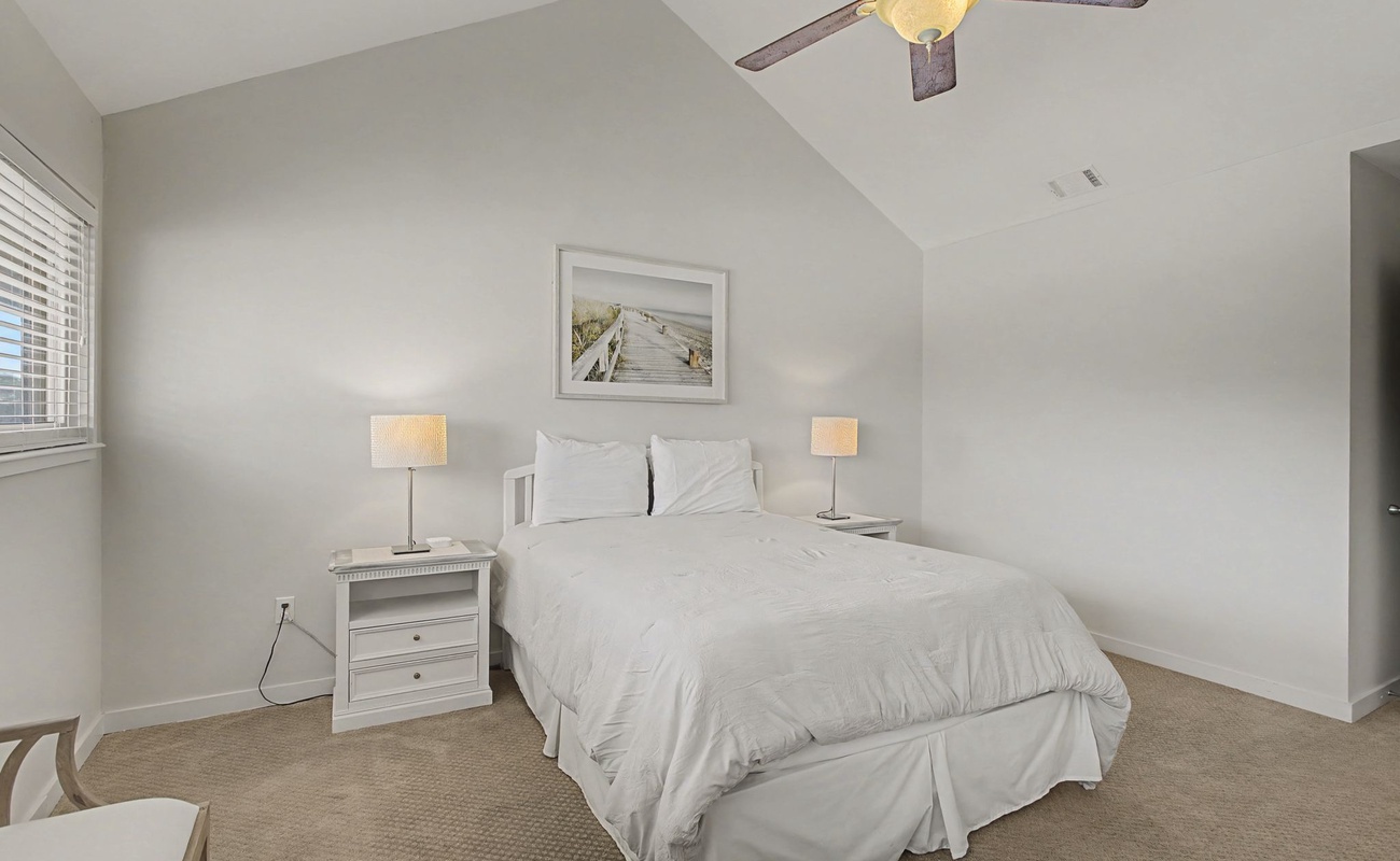 Drift off to peaceful sleep in your serene bedroom, complete with plush white linens and gentle bedside lighting for ultimate comfort.