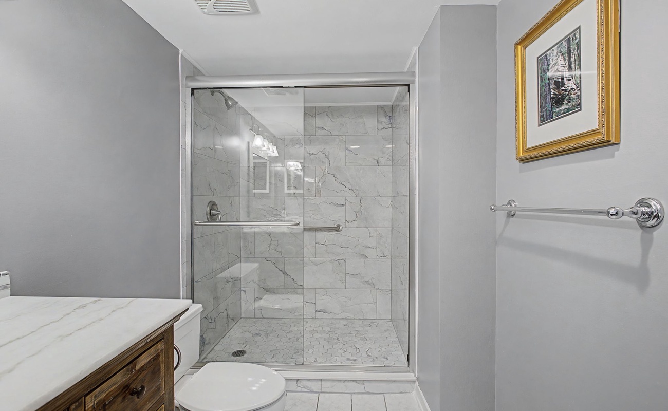 Step into your beautifully renovated bathroom featuring elegant marble-look tiles and a spacious walk-in shower where you'll feel pampered every morning.