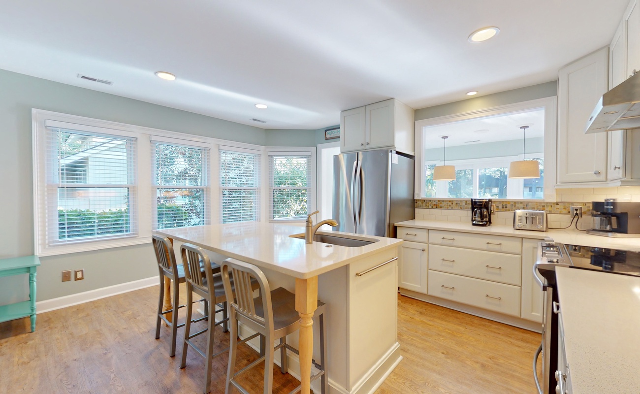 Spacious kitchen with white cabinets, granite countertops, and breakfast island creates your perfect culinary retreat.