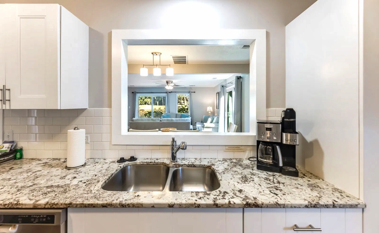 Your granite countertops and coffee maker await, while the pass-through window connects you to the bright living space beyond.