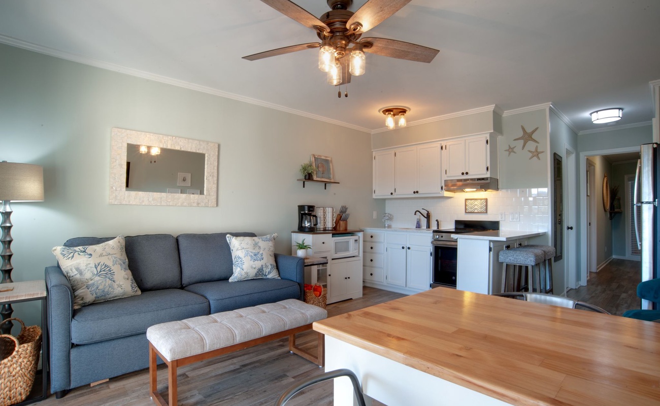 Relax in your bright, coastal-inspired retreat where soft blues and whites create perfect harmony. Your open-plan space flows beautifully from cozy seating to modern kitchen.