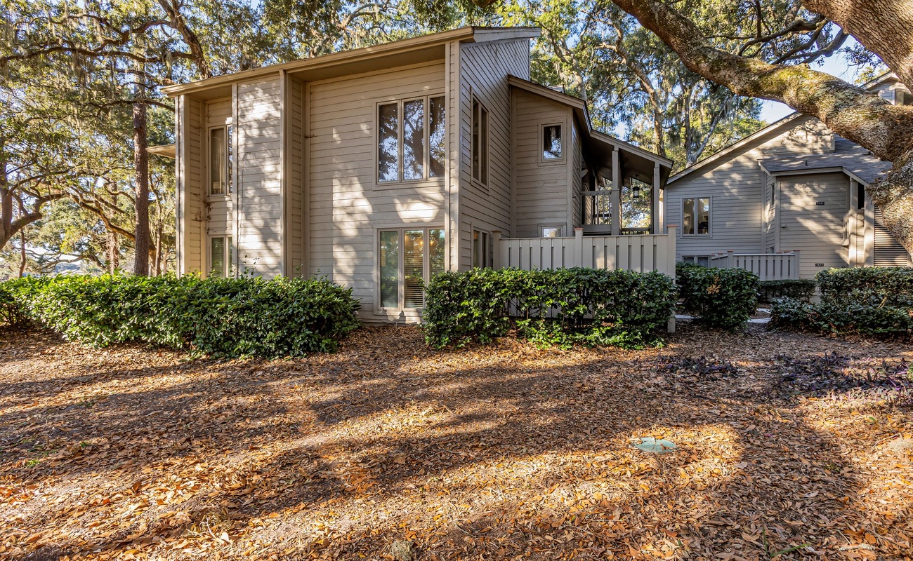 Charming multi-level home nestled among mature oak trees in a serene, landscaped setting.