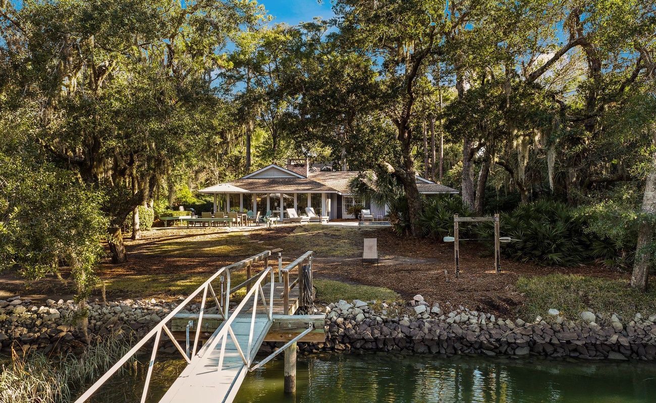 Waterfront retreat with private dock nestled among mature trees, offering serene lakeside tranquility.