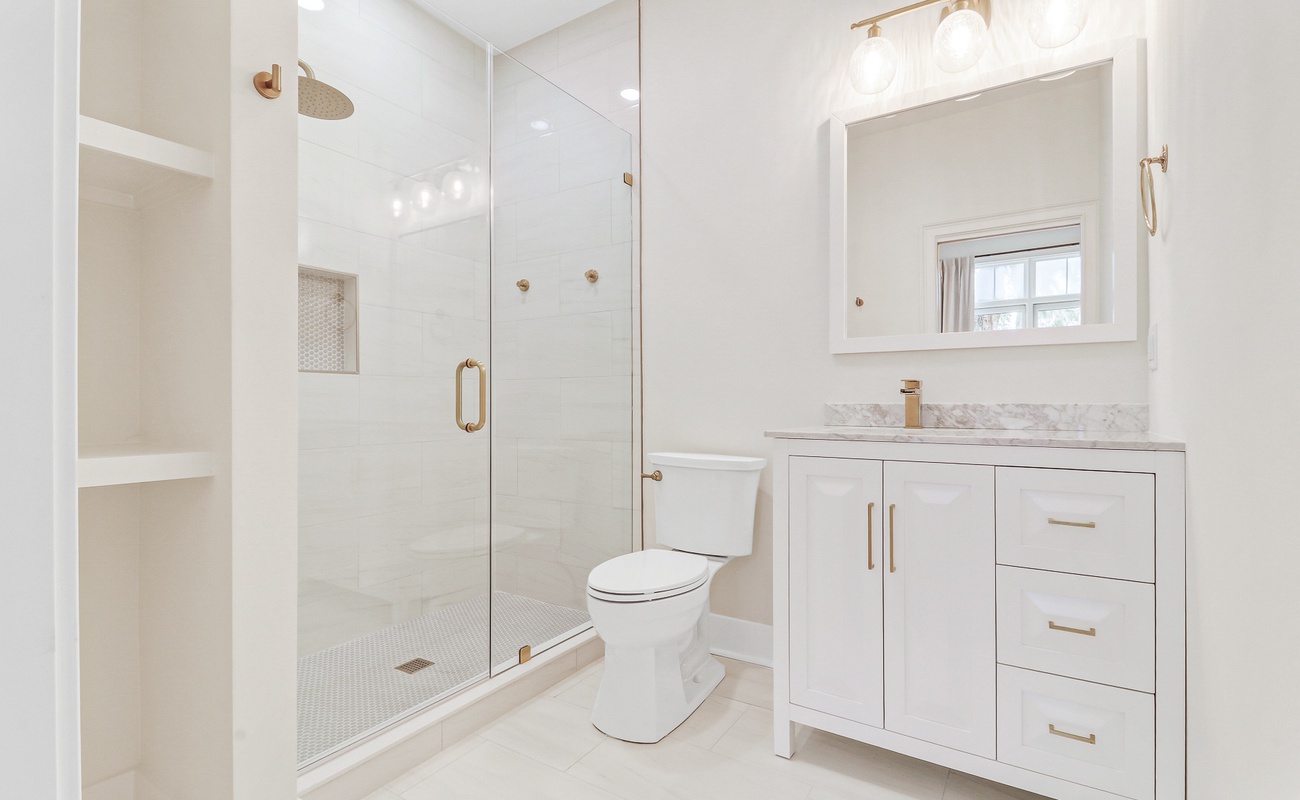 Your private spa-like bathroom features a luxurious walk-in shower with elegant gold accents and marble details throughout.