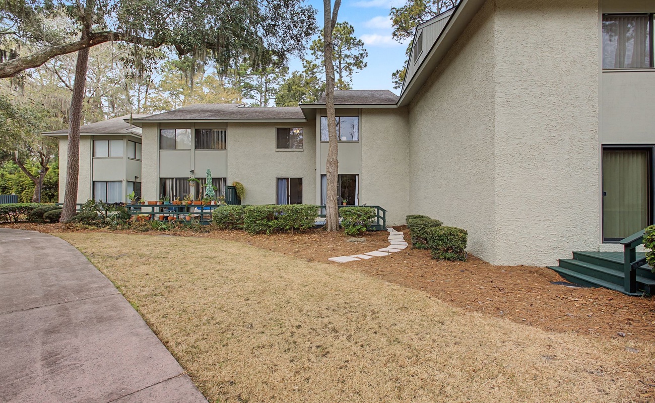 Modern property nestled among mature trees in a peaceful residential setting with well-maintained landscaping and convenient walkways.