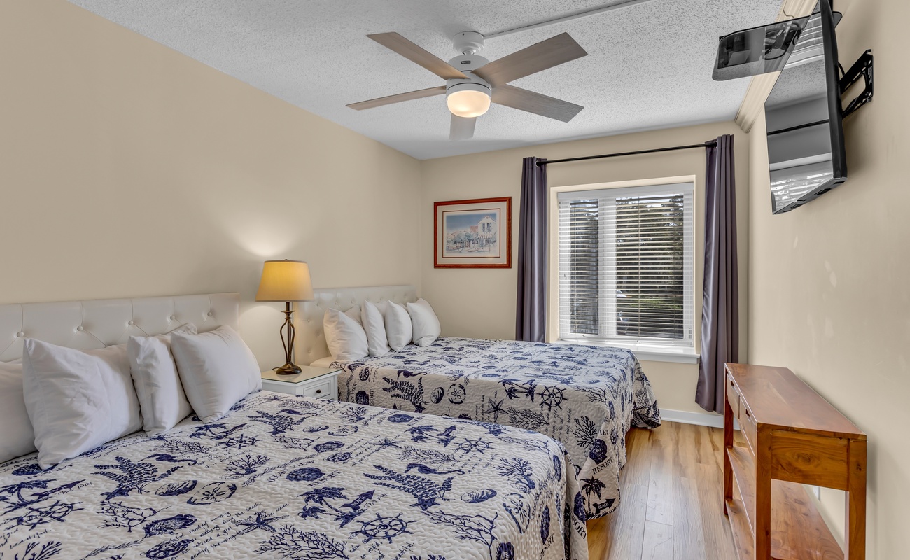 Drift off to sleep in your cozy twin bedroom, where nautical-themed bedding and gentle ceiling fan breezes create the perfect coastal retreat.