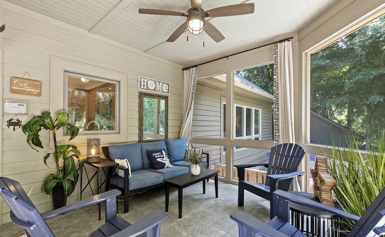 Unwind on your screened porch with comfortable seating and ceiling fan, perfect for morning coffee or evening relaxation.