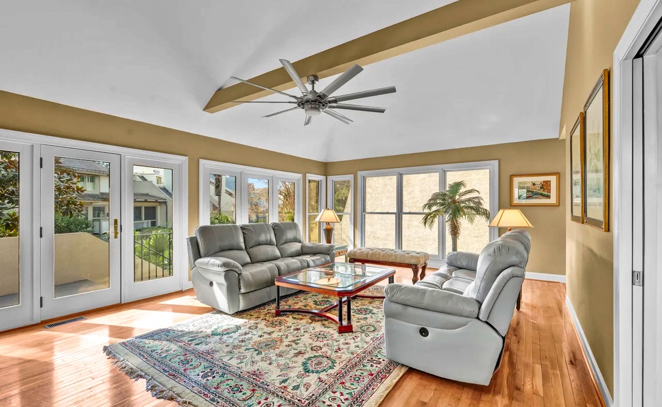 Unwind in your bright living room with plush recliners, hardwood floors, and French doors opening to peaceful views.