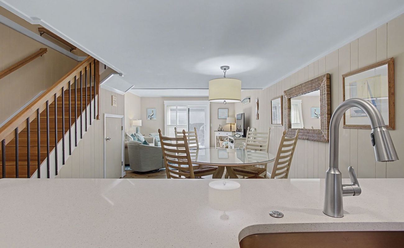 From your kitchen, watch conversations flow between the dining area and living room in this thoughtfully connected coastal space.