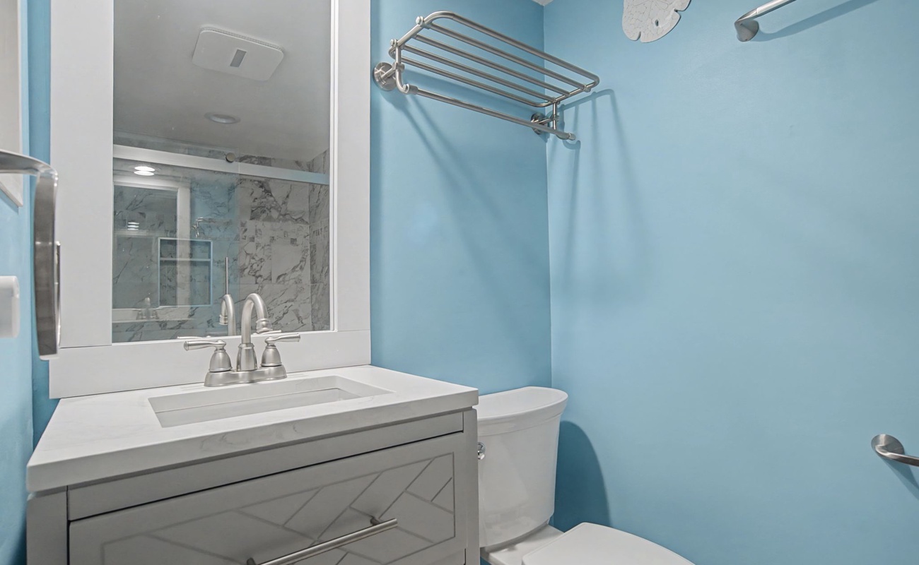 Refresh in your bright, coastal-inspired bathroom featuring modern fixtures and soothing blue walls.