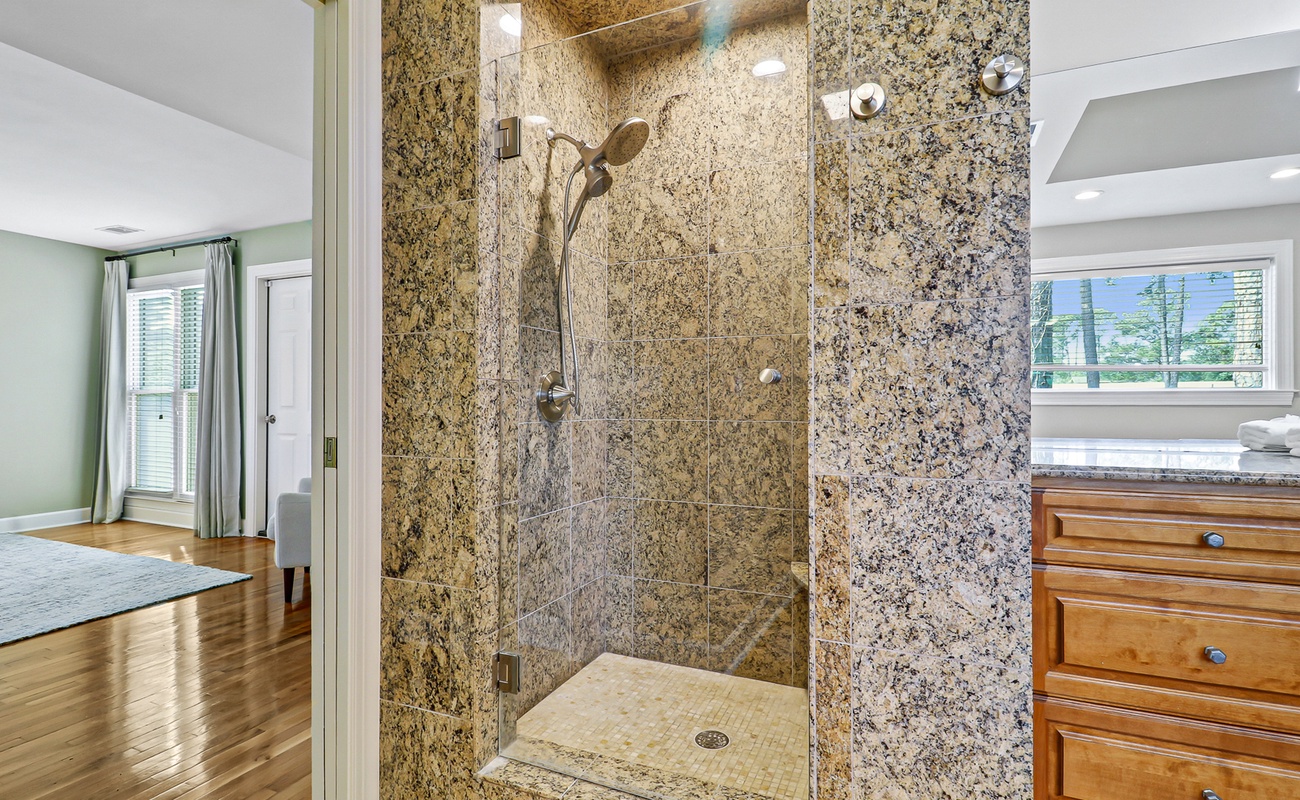 Step into your spa-like granite shower with rainfall head, where polished stone surrounds create a luxurious daily escape.