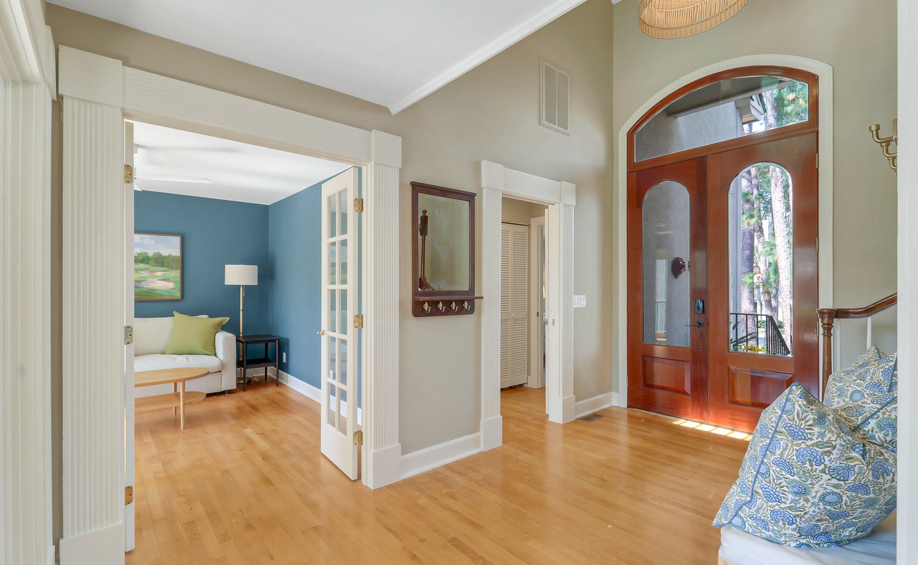 Step into your welcoming entryway where warm wood floors and elegant archways create an inviting atmosphere for your stay.