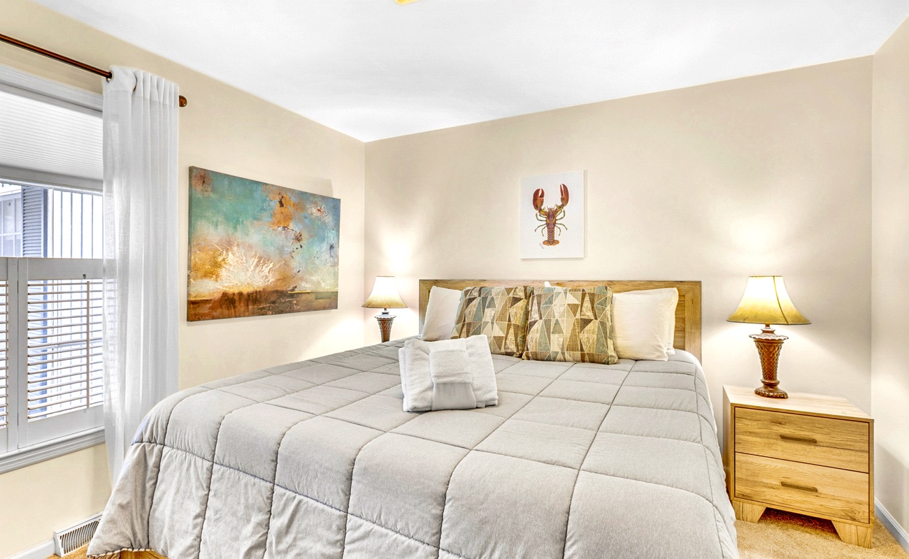 Unwind in your cozy bedroom with coastal artwork and plush bedding for peaceful nights.