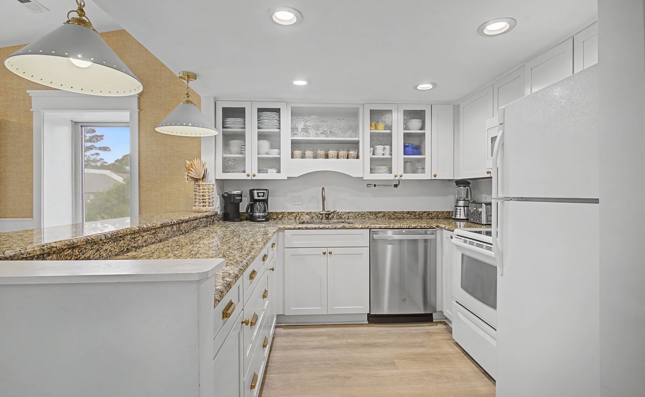 You'll love preparing meals in this bright, fully-equipped kitchen with granite countertops, stainless appliances, and pendant lighting.