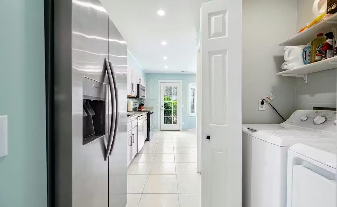 Your bright, modern kitchen connects seamlessly to a convenient laundry area, making meal prep and daily chores effortless during your stay.