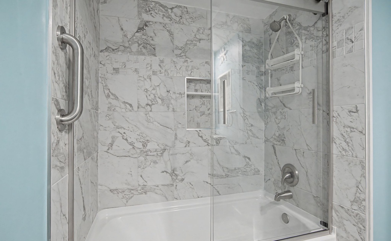 Step into your guest bathroom where luxury meets comfort - a pristine shower-tub combo awaits your relaxation.