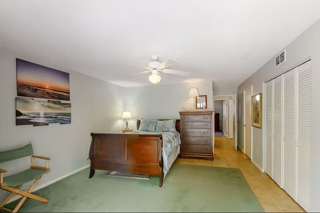 Unwind in your spacious bedroom featuring a cozy sleigh bed, ceiling fan, and soothing sea-themed artwork that creates the perfect retreat.