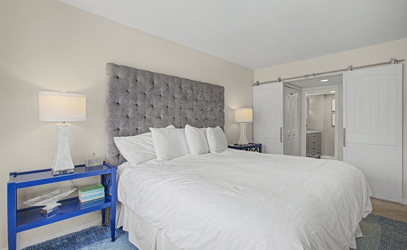 Sink into luxury with crisp white linens and a plush tufted headboard in your peaceful retreat.