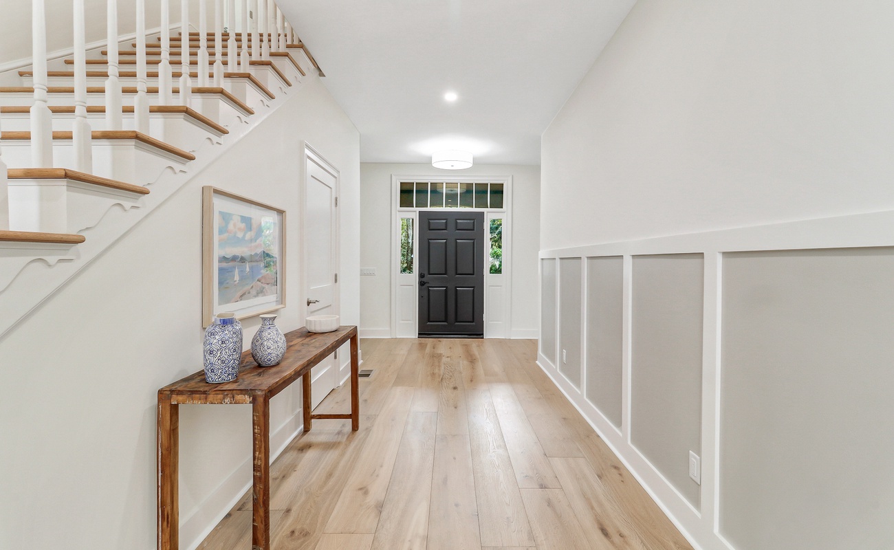Step into your bright, welcoming entryway where warm wood floors meet elegant white walls, creating the perfect first impression for your stay.