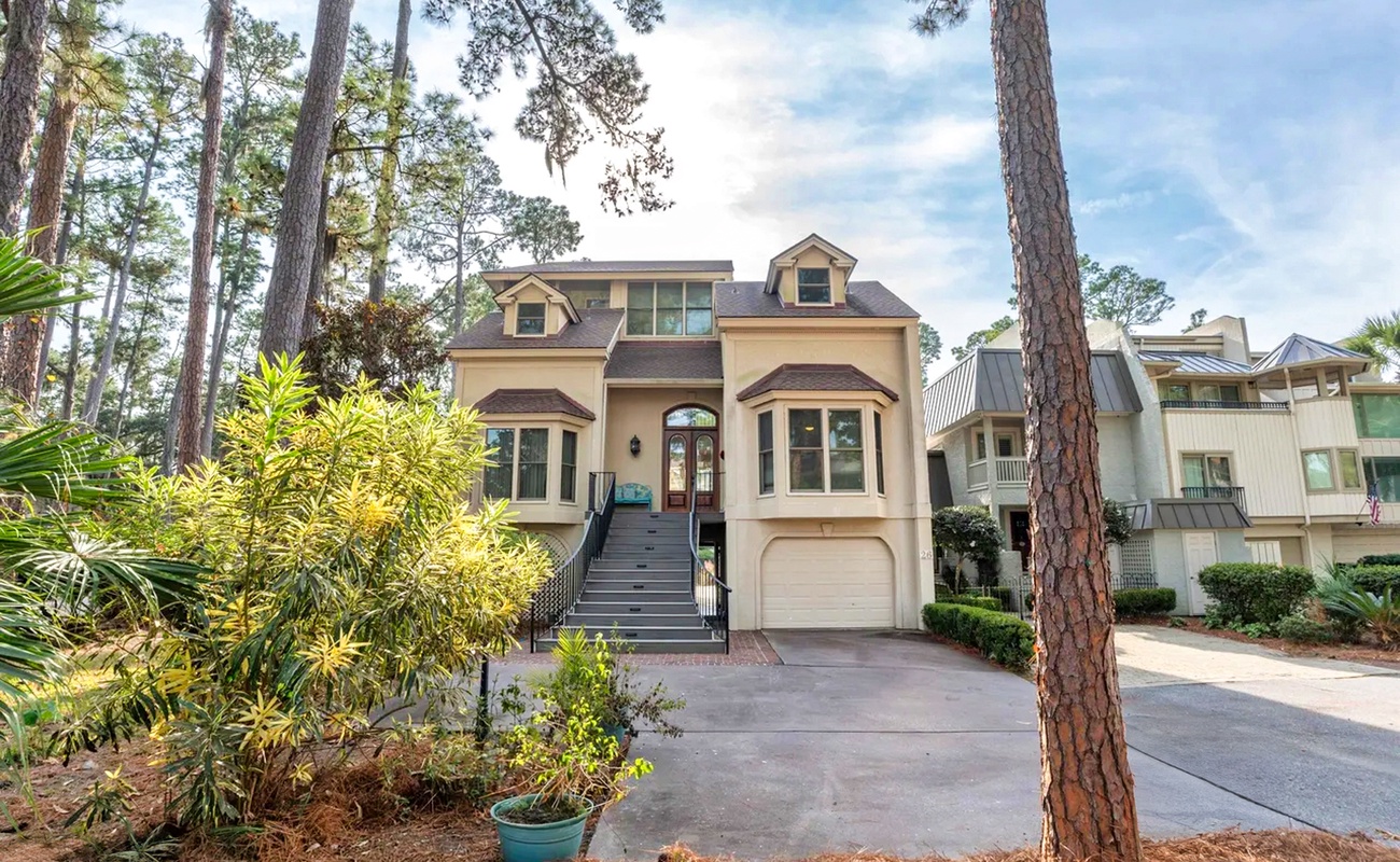 Beautiful vacation home nestled among towering pines with lush tropical landscaping and convenient parking.