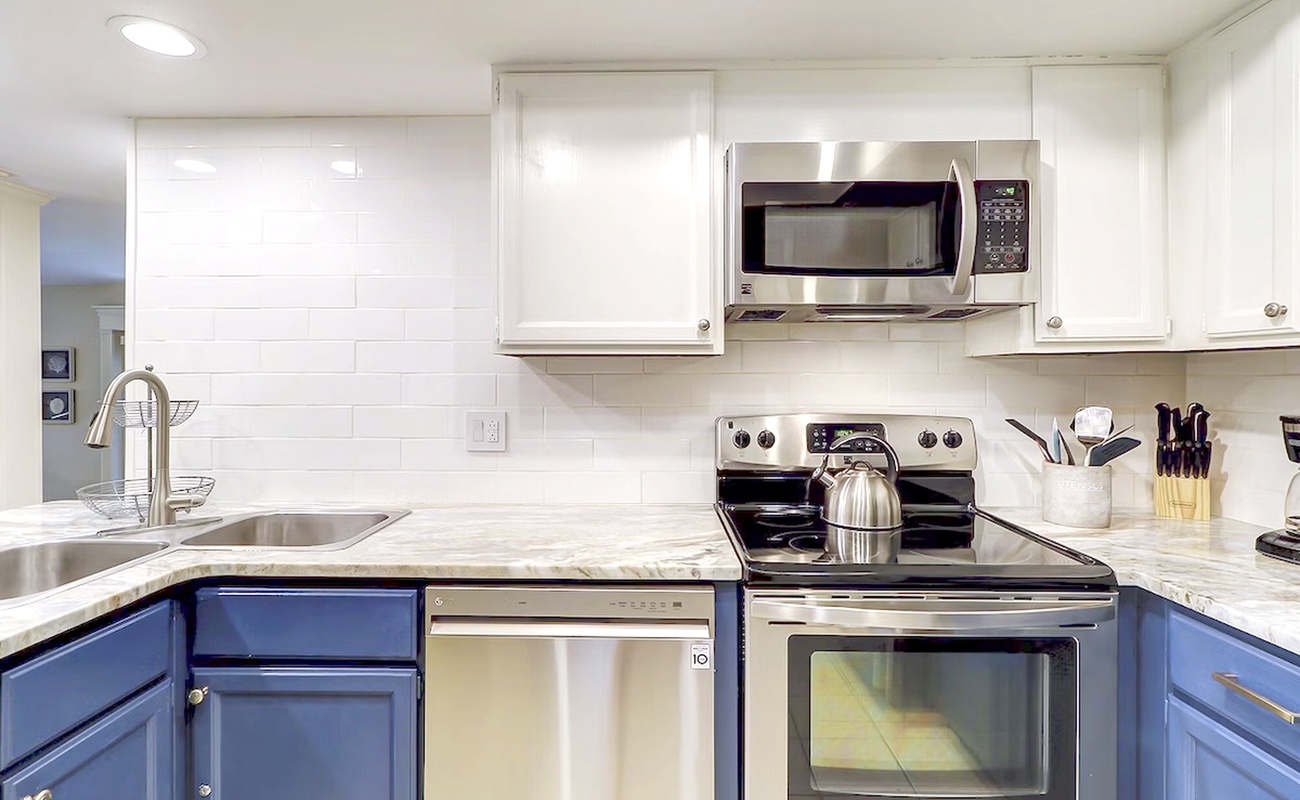 Your fully equipped kitchen features modern appliances and stylish blue cabinets, perfect for preparing your favorite meals during your stay.