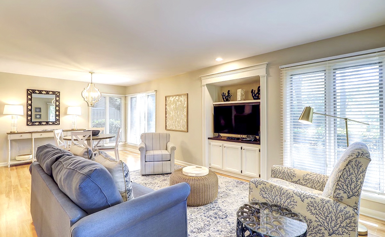 Relax in your bright living room with plush seating, entertainment center, and sunny windows overlooking peaceful surroundings.