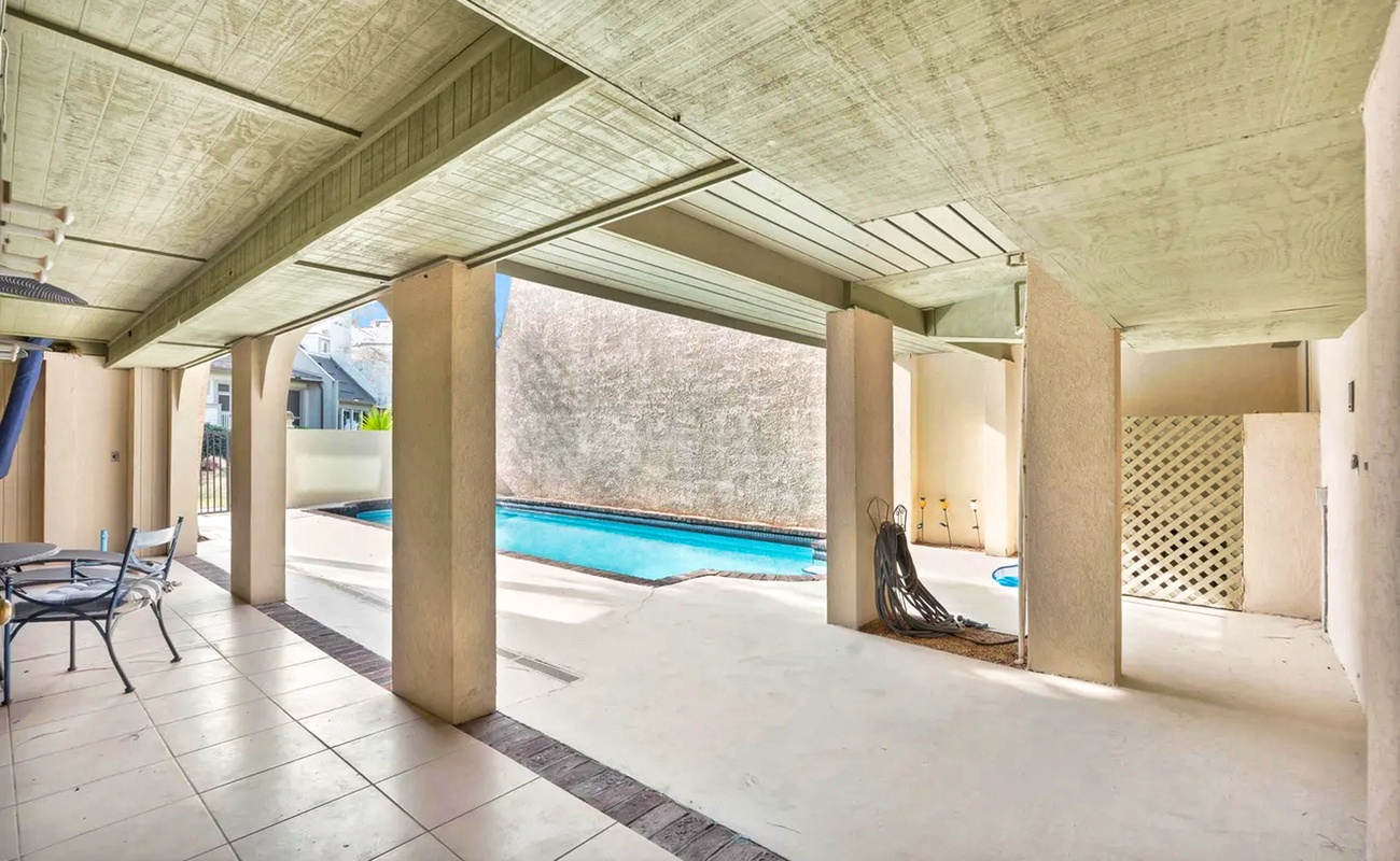 Step into your private covered patio where cool shade meets poolside relaxation, perfect for enjoying morning coffee or afternoon lounging.