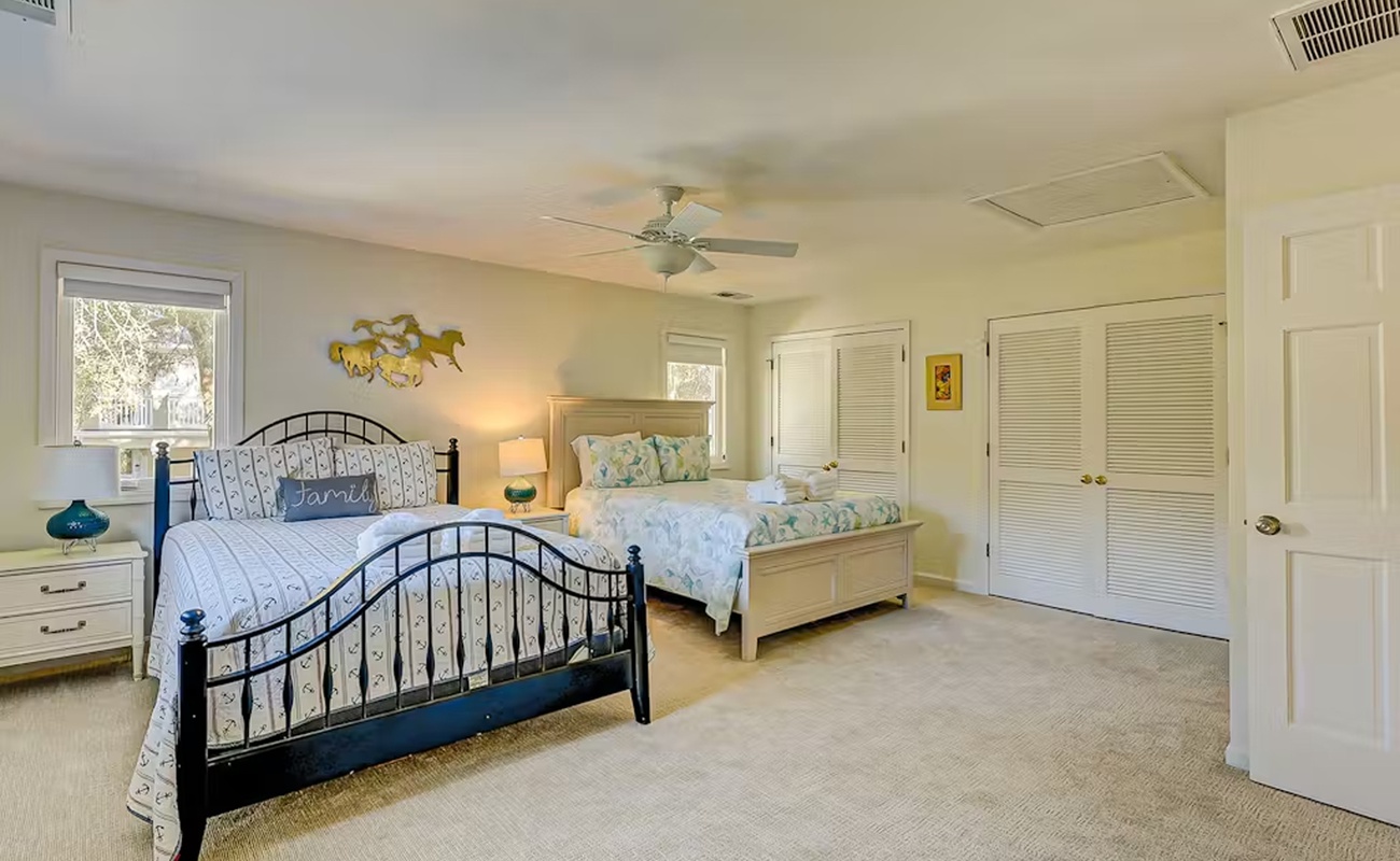 Spacious bedroom with comfortable beds for your family, featuring plenty of natural light and ample storage for all your vacation essentials.