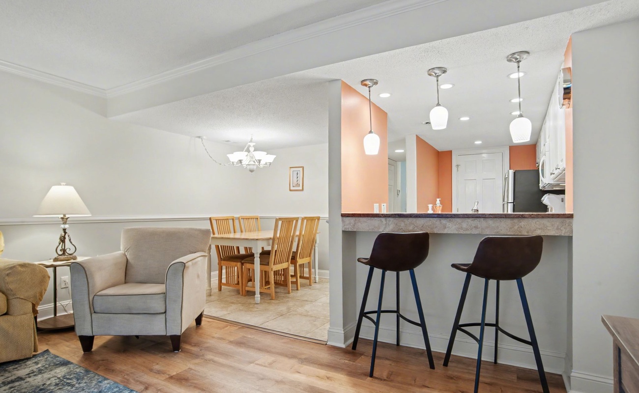 Relax in your open-concept living space featuring a modern kitchen with breakfast bar and cozy seating area perfect for unwinding.