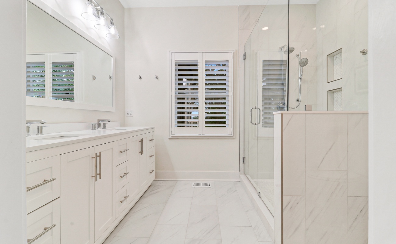 Step into your luxurious marble bathroom featuring a spacious glass shower and elegant vanity for your morning routine.