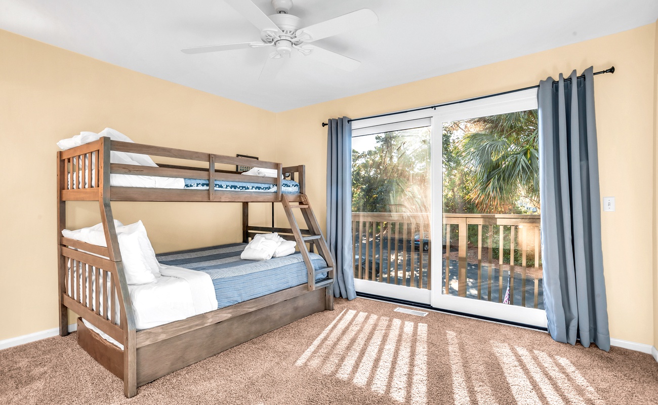 Sleep peacefully in this cozy bunk room where sunlight streams through your private balcony doors onto soft carpeting.