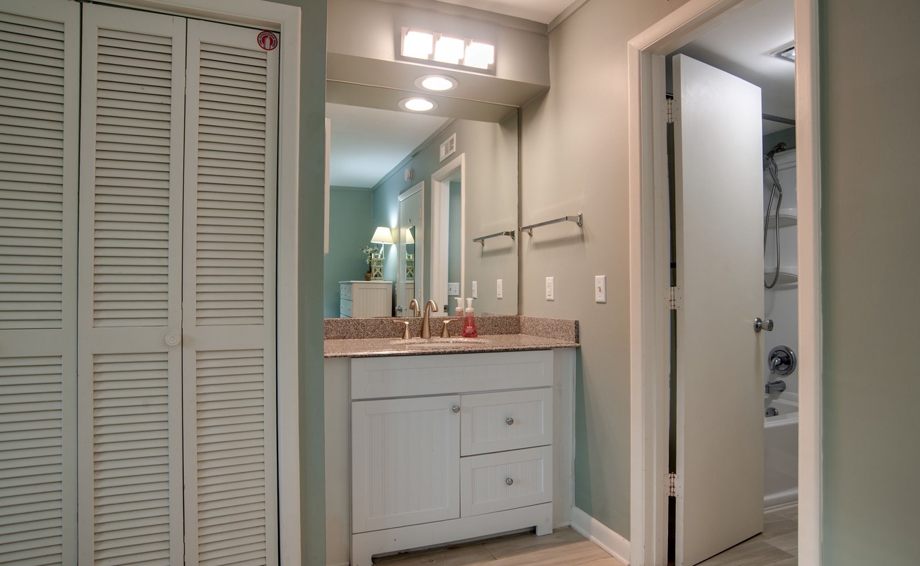 You'll appreciate the coastal-inspired bathroom with granite countertops, ample storage in white louvered closets, and thoughtful lighting for your daily routines.