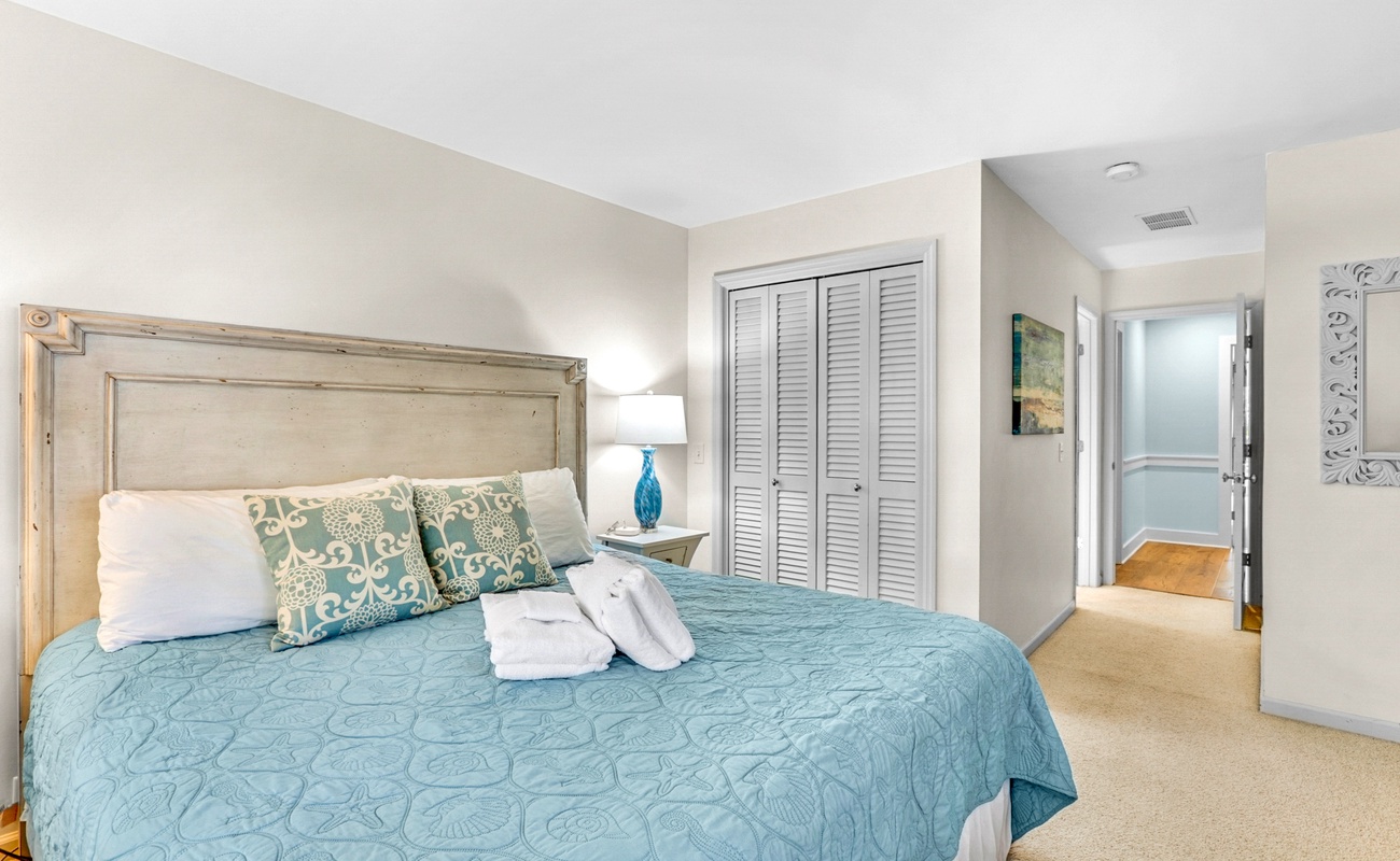 Sink into soft linens and coastal-inspired decor in this peaceful bedroom retreat with ample storage and natural light.