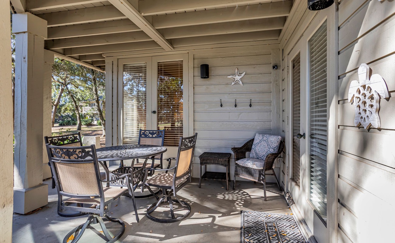 Your private covered patio invites peaceful mornings with coffee and evening conversations under the gentle shade of mature trees.