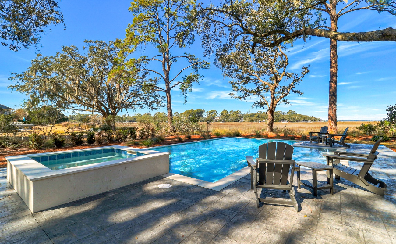 Private pool and spa surrounded by native trees and rolling landscape views.