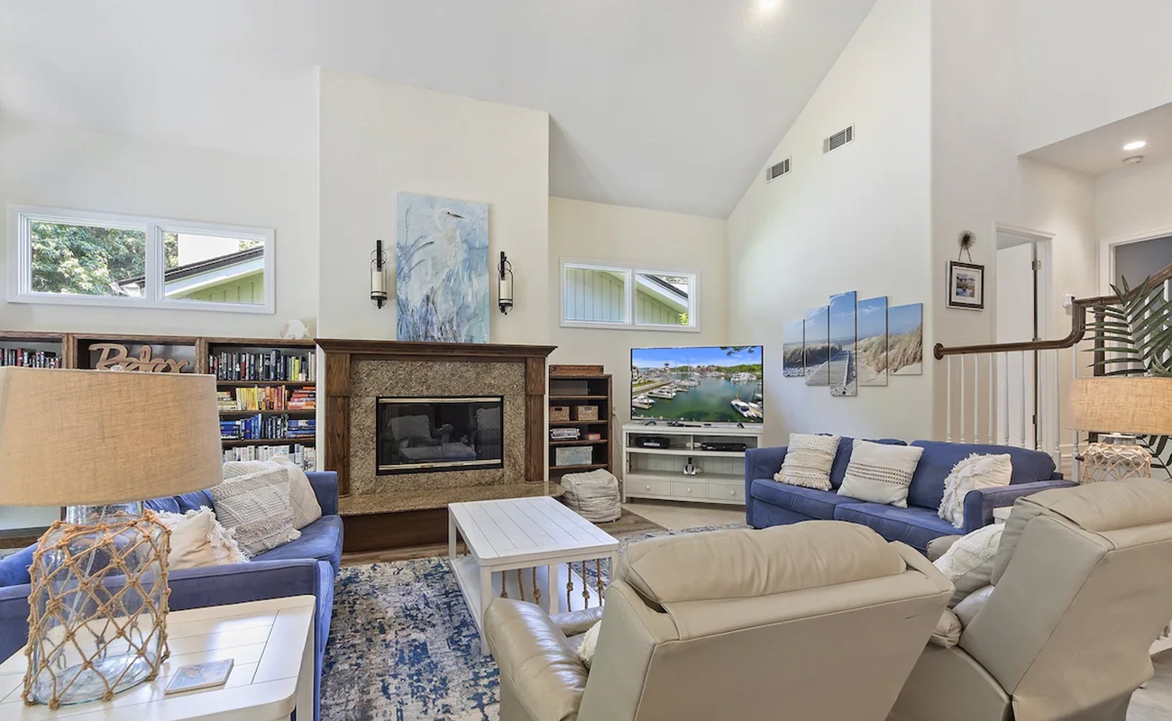 Sink into plush seating by the fireplace, browse books from the built-in shelves, and enjoy cozy evenings in this bright, airy living space.