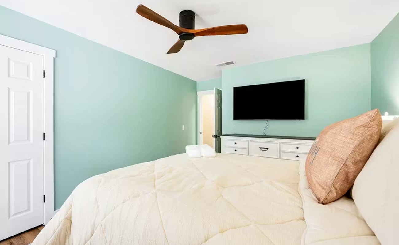 Rest peacefully in your serene bedroom with calming mint walls, plush bedding, and entertainment at your fingertips.
