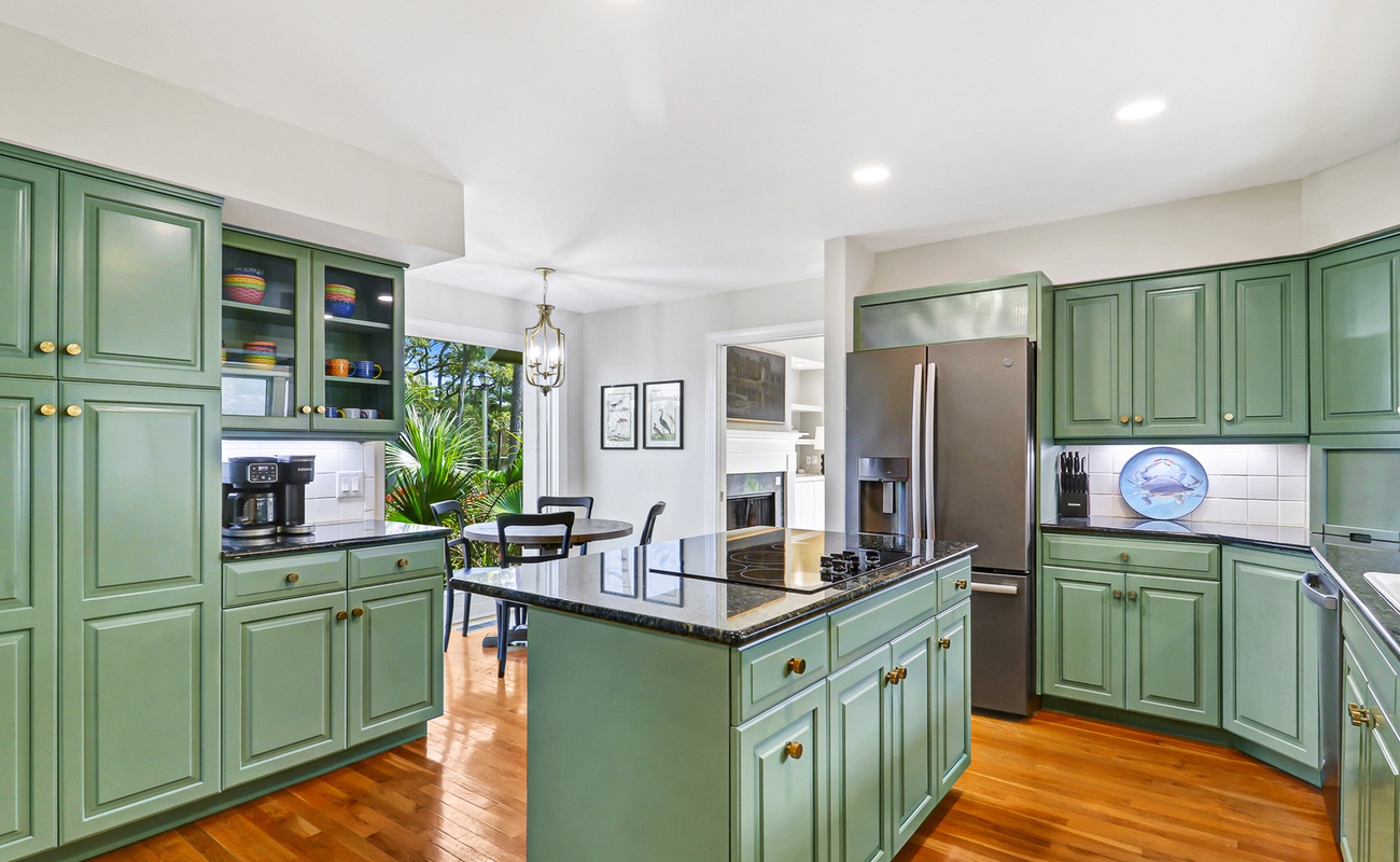 Cook and entertain with ease in your spacious kitchen featuring sage-green cabinetry, granite countertops, and premium appliances.