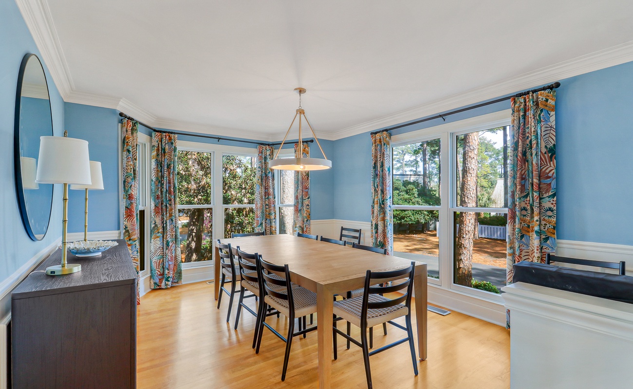 Gather around your elegant dining table for memorable meals, bathed in natural light from large windows overlooking peaceful garden views.