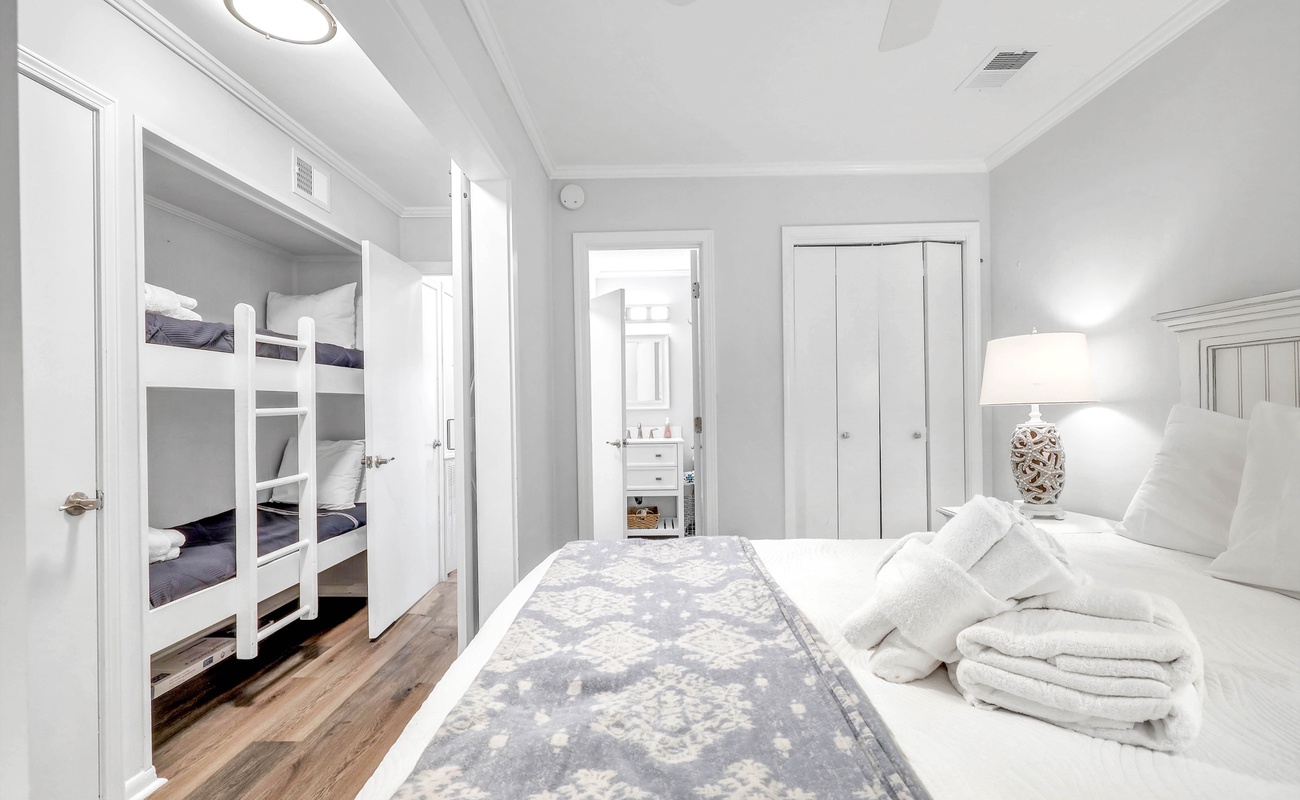 Primary Bedroom with Queen Bed and View of Bunk Beds in Hallway